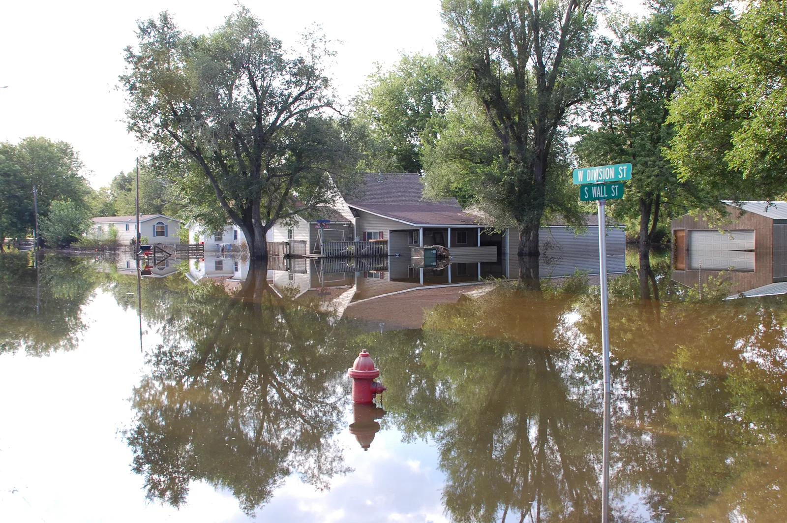 Residential street flooded with water reaching home porches